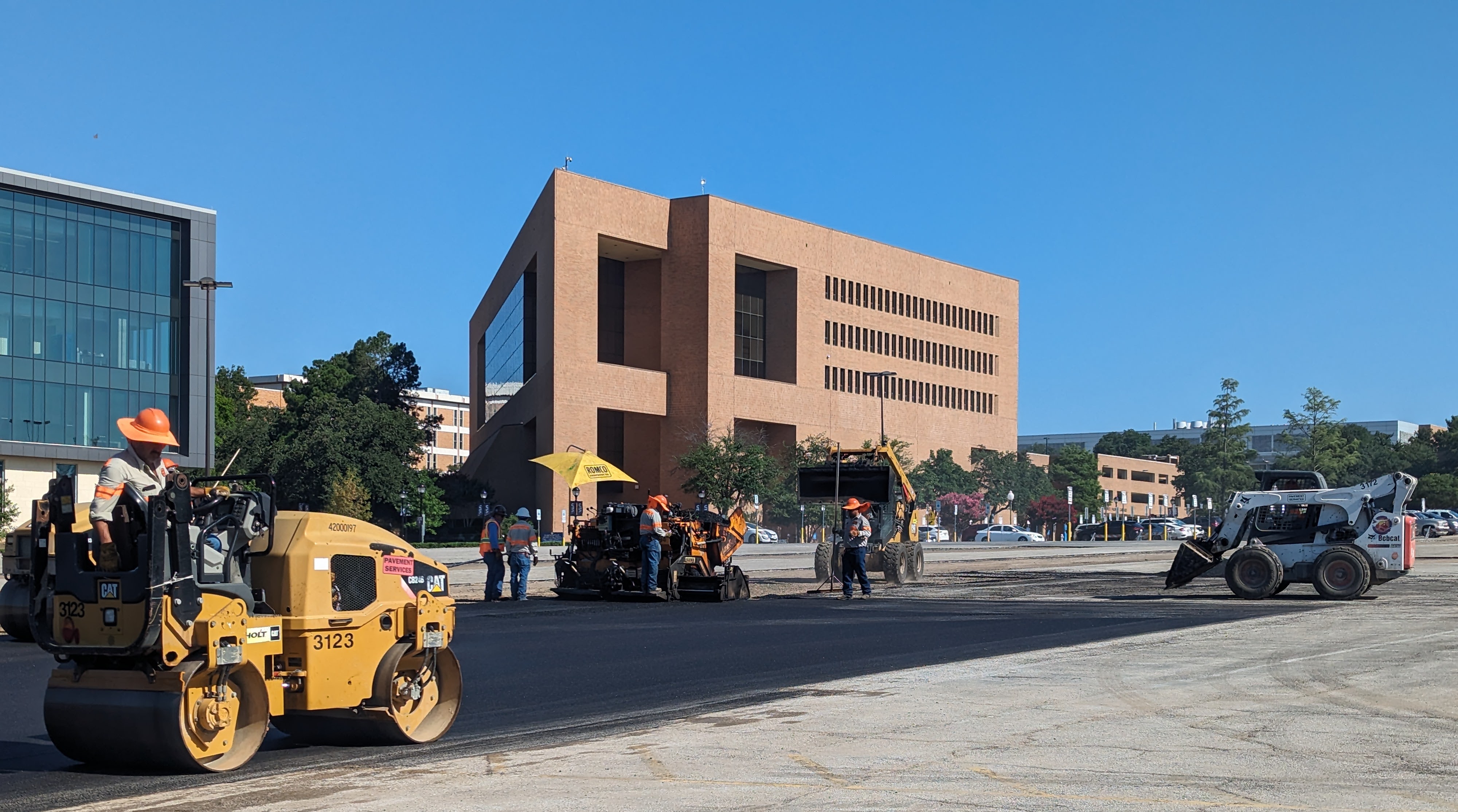 An image of workers paving a parking lot with the plastic asphalt